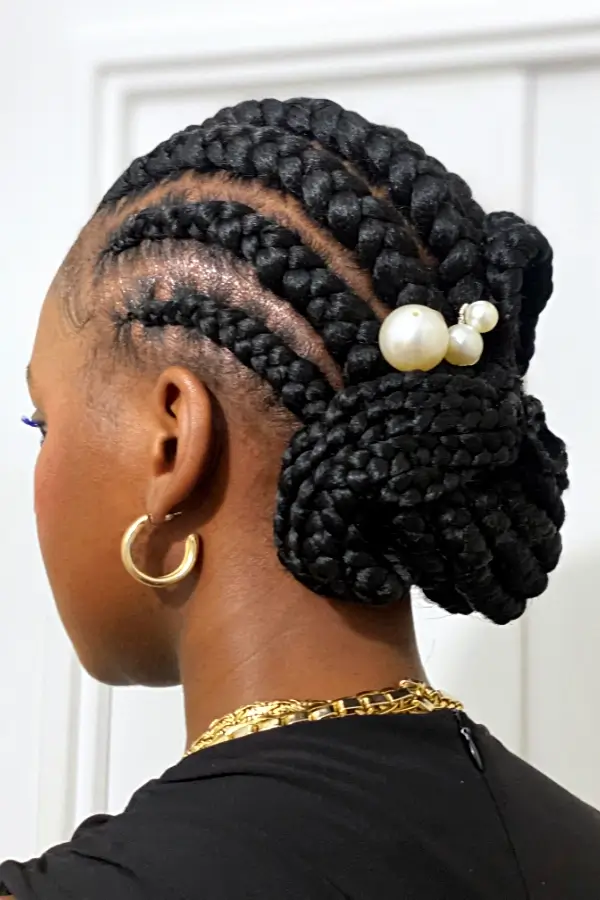 Portrait d'une femme vue de dos, portant un chignon étoile et des nattes collées